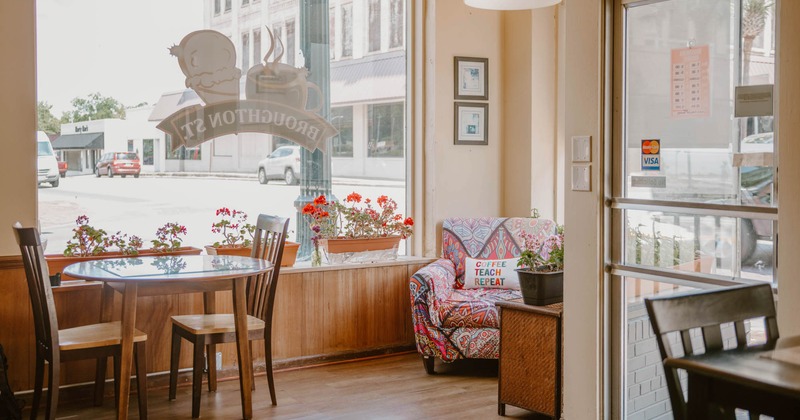 Interior, seating area, entrance, shop window, comfy armchair in the corner, table for two