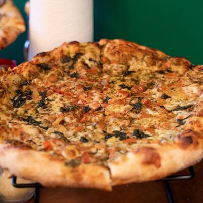 Margherita Pizza served on a black metal stand, close-up.