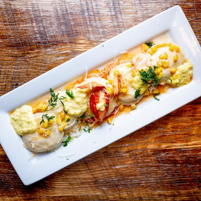 Lobster ravioli served on a rectangular white plate.
