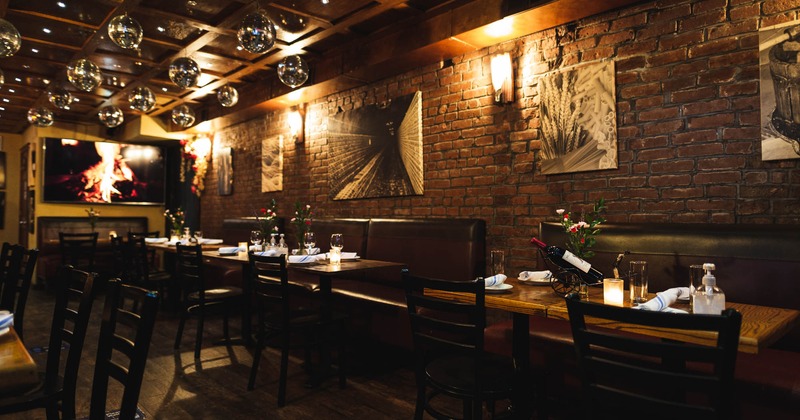 Inside, art on the wall, tables, chairs, booths