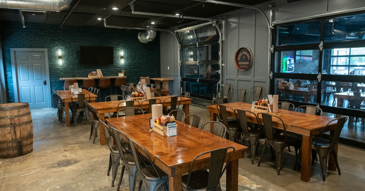 Interior, open space dining area, wooden top tables ready for guests, sliding doors