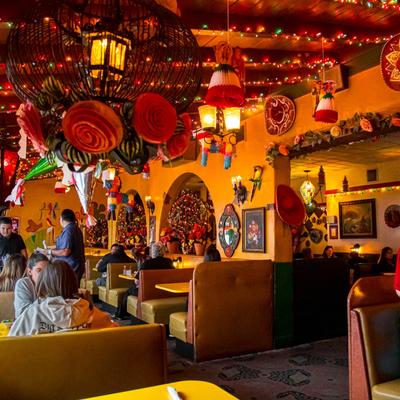 Vibrant interior with booth seating, wall art, and festive decorations.