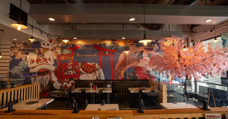 Restaurant interior with Japanese-themed mural and cherry blossom decor