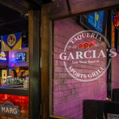 Sports bar interior with a window decal featuring the business logo.
