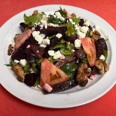 Mixed salad with beets, tomatoes, greens, goat cheese, and pecans.