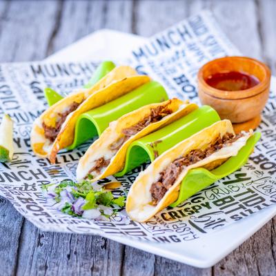 Birria tacos served with a dippng sauce.