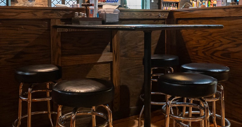 Interior of a bar with barstools, a high table