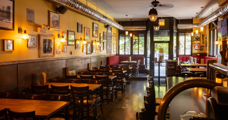 Interior, wooden tables, red booths, framed wall art, a bar