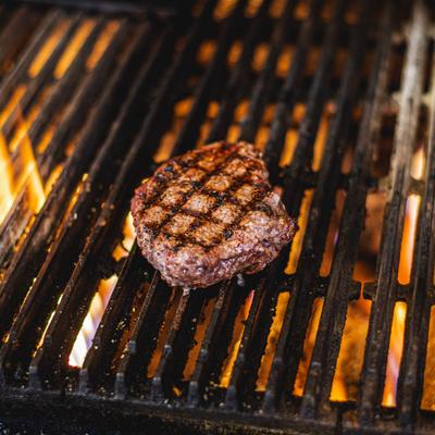 Steak cooking over a charcoal grill.