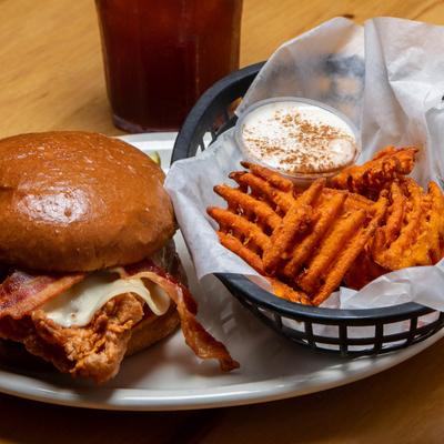 Fried chicken sandwich with bacon, waffle sweet potato fries, and creamy dipping sauce.