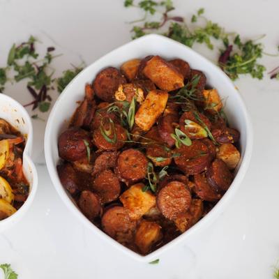 Sausage and potato skillet with herb garnish.