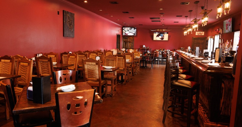 Interior of a cozy restaurant with red walls, wooden tables and chairs