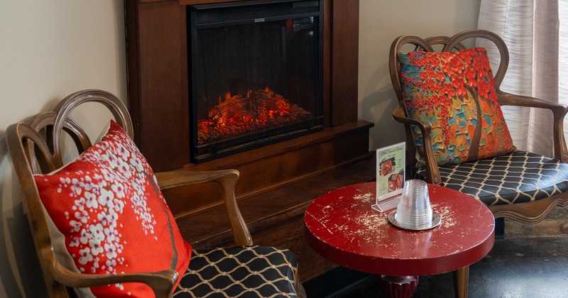 Coffe table, armchairs, fireplace behind
