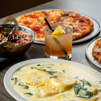 Assorted food dishes and a cocktail drink, close up.
