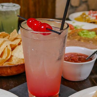 Pink cocktail garnished with maraschino cherries.