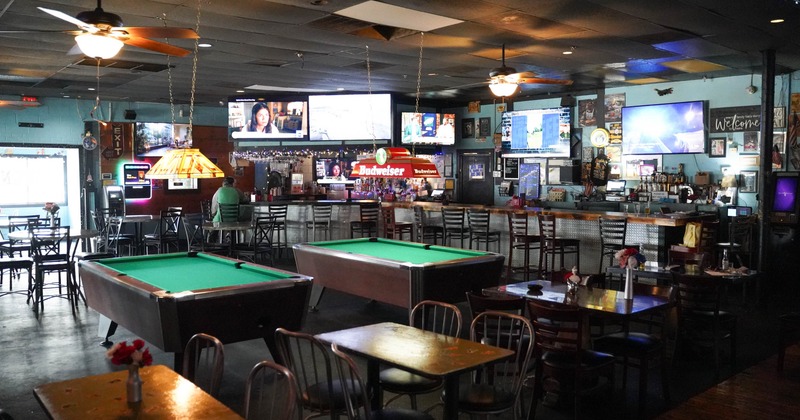 Interior, dining tables, green pool tables, multiple TVs on the walls