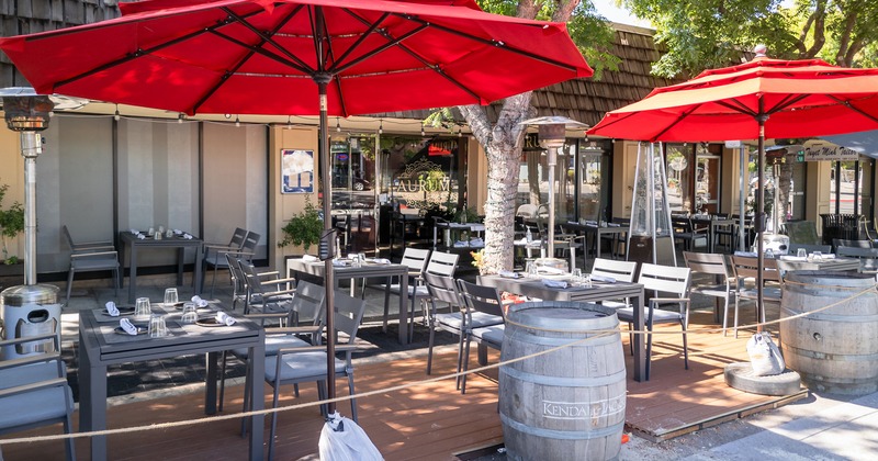 Outdoor seating area with set dining tables and red parasols