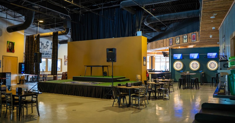 Interior, dining and stage room, tables with chairs, indoor stage with sound system