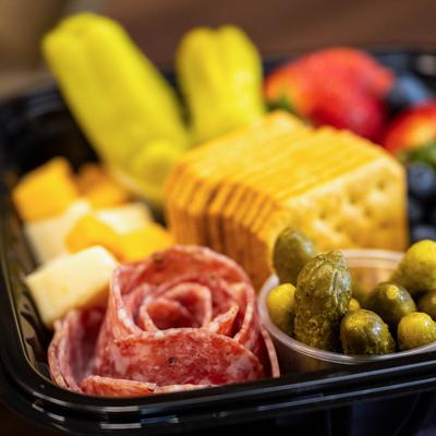 Charcuterie in a takeout container.