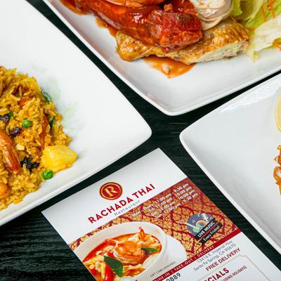 Multiple food plates and a menu on a table.