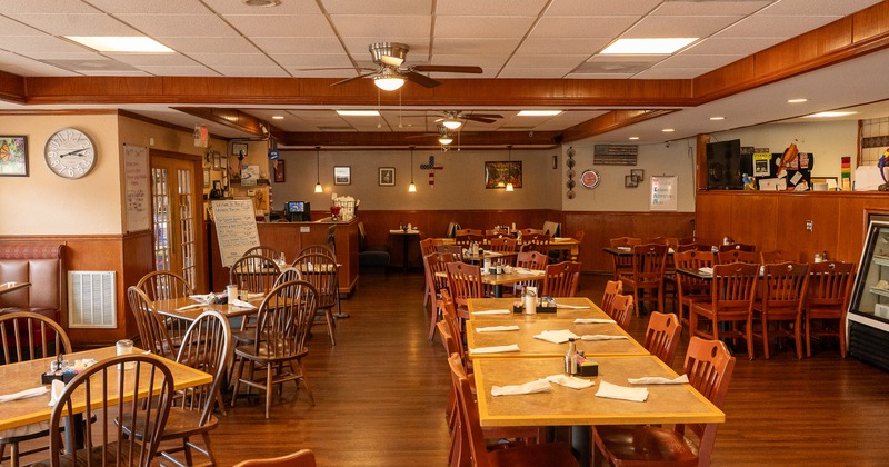 Spacious, cozy, and rustic interior dining area with tables set for guests
