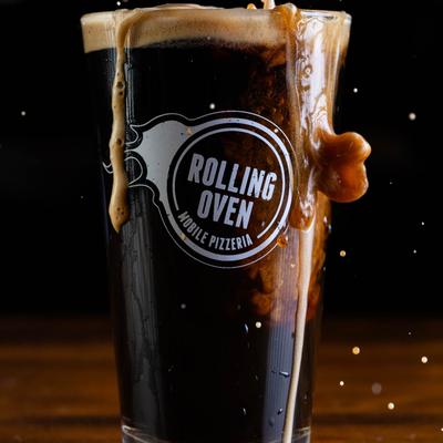 Stout beer in a glass with Rolling Oven logo.