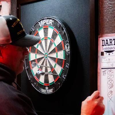 Person playing a game of darts on a dartboard.