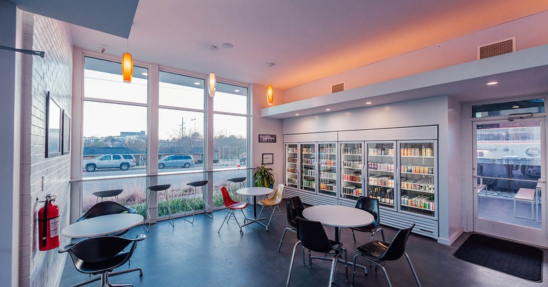 Interior, seating area, large refrigerator with various drinks, back door, large shop window