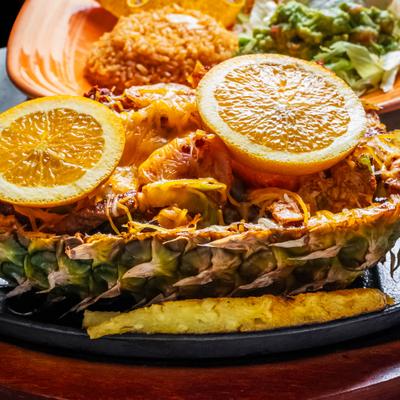 Grilled pineapple filled with grilled chicken, closeup.