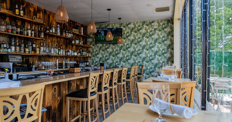 Interior, bar and high seating area, wooden top bar with stools, high tables for two