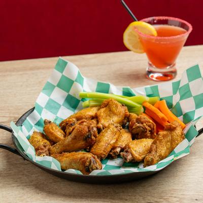 Lemon pepper wings with celery and carrots, accompanied with Tropical Cosmo.