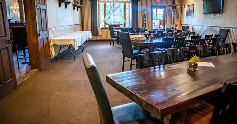 Interior, tables set for guests, entrance door and a window in the back