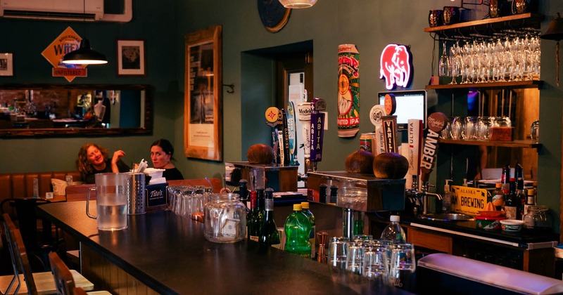 Bar interior with beer taps, neon lights, and glassware