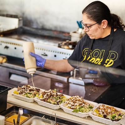 Employee pouring sauce.