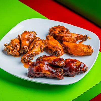 A plate with BBQ, Mango Habanero, and Buffalo wings.