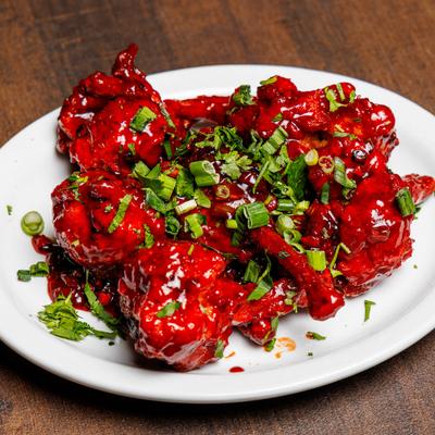 Marinated chicken drumettes, topped with scallions.