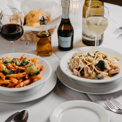 Salsa la bona pasta and Shrimp Alfredo with red and white wine glasses.