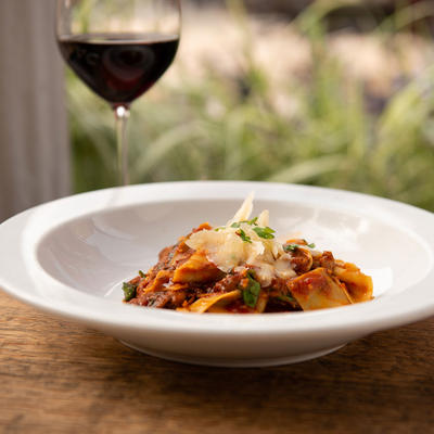 Bolognese pasta and a glass of wine closeup
