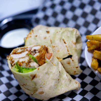 Chicken wrap served with fries and a dipping sauce.