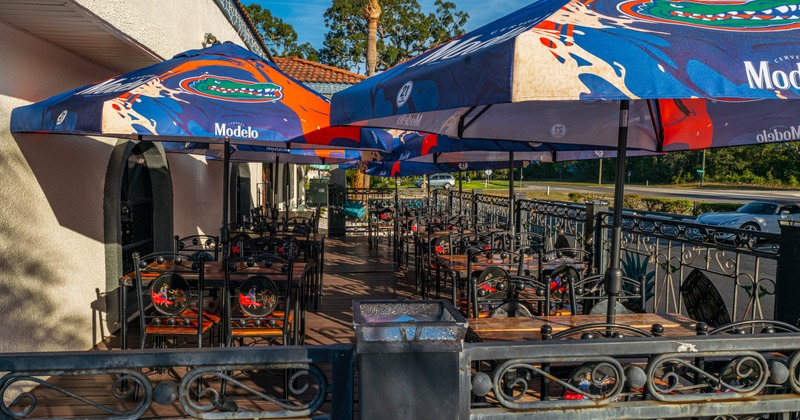 Exterior, seating area, iron frame chairs with wooden top tables under parasols, wooden decking
