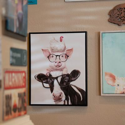 Framed pictures of cows and pigs.