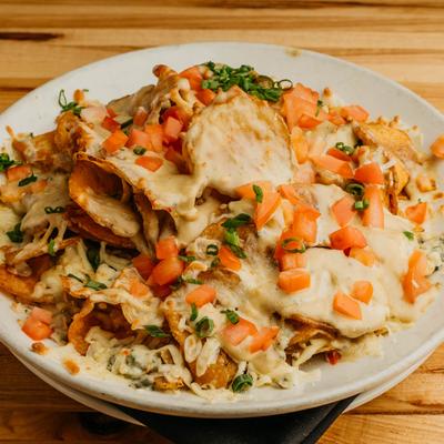 Potato chips with Maytag Blue cheese, pepper jack cheese, tomatoes, and scallions.
