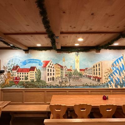 Interior with wooden furniture and a mural of Straubing.