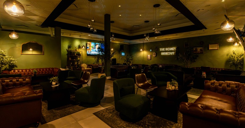 Interior, lounge area, comfy sofas and armchairs with coffee tables, dim and soft lighting