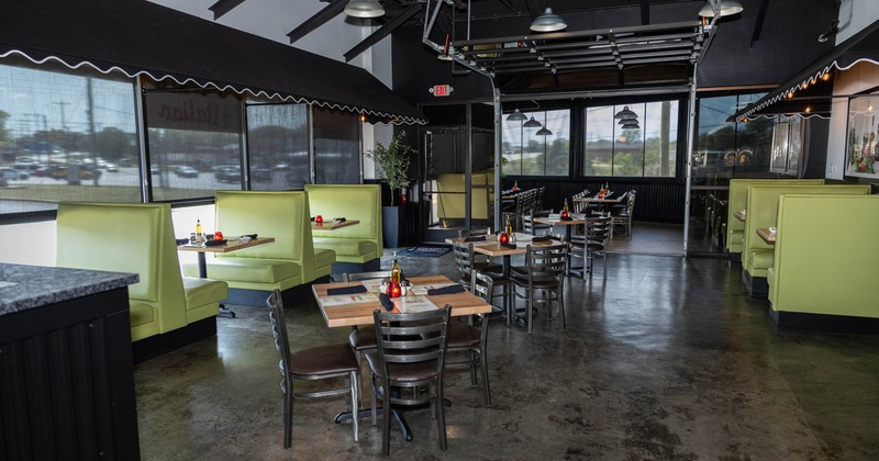 A modern interior - light green booths, wooden tables and industrial lighting
