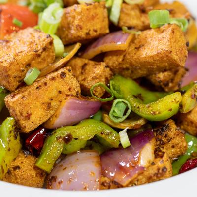 Stir-fried tofu with bell peppers, onions, and chili peppers.