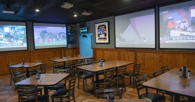 Seating tables and large TV screens on the walls