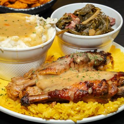 Turkey wing served with rice, collard greens and mashed potatoes.