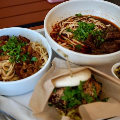 Hot Dry Noodles, Noodle Soup with Meat, Bao buns, and pickled vegetables.