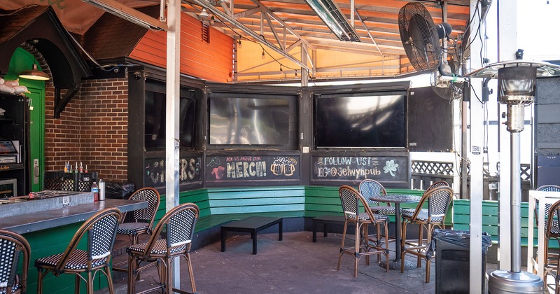 Covered patio, seating area near the bar, TV sets
